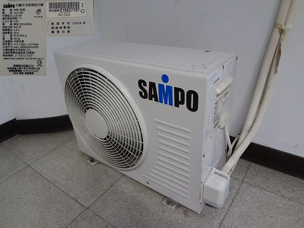 聲寶分離式冷氣室外機直接放置在地面上，背面緊貼牆壁。