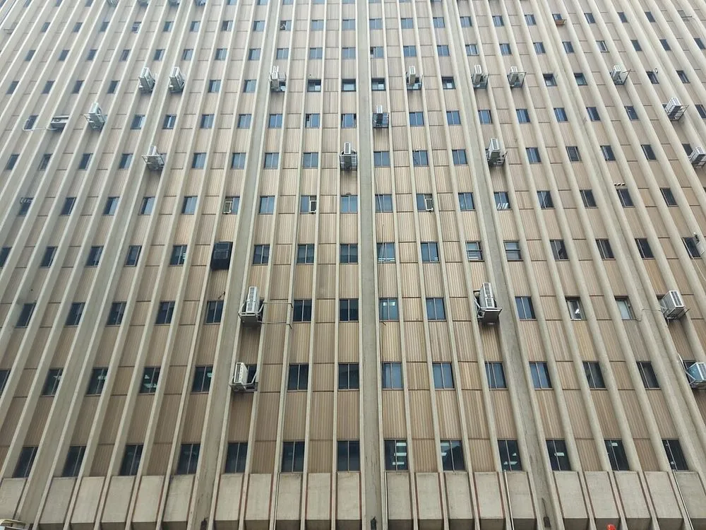 辦公大樓外牆整面的百葉開口，後方裝設分離式冷氣室外機。